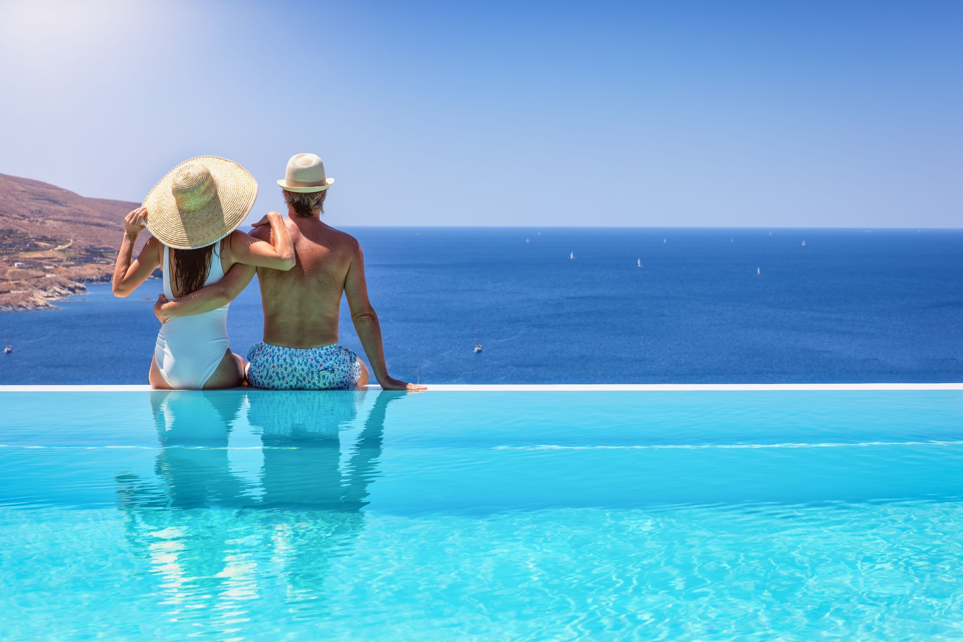 A couple hugging at the edge of an infinity pool