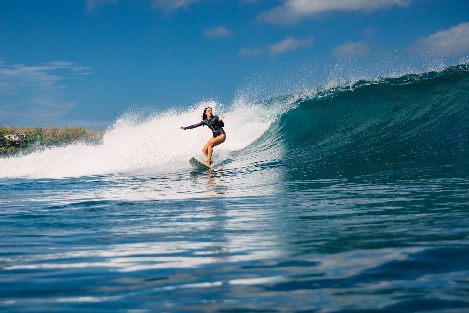 Surfer woman on surfboard during surfing. Surfer girl riding on perfect ocean wave